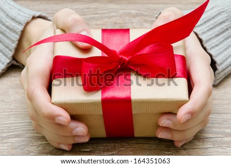 gift box tied with a red ribbon in the hands