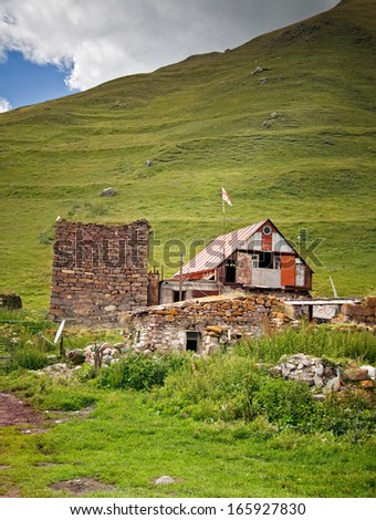 house with Georgian flag in Georgian mountains