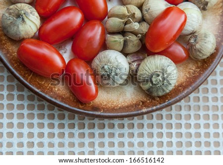 cherry tomatoes and garlic on a brown plate