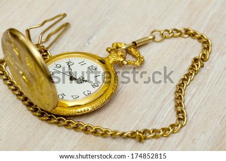 vintage pocket watch on a gold chain on the table