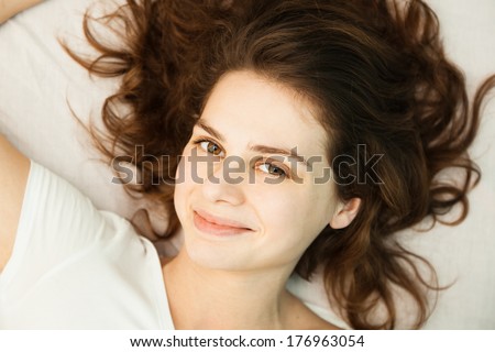 portrait of a beautiful young woman with curly hair, shot from above