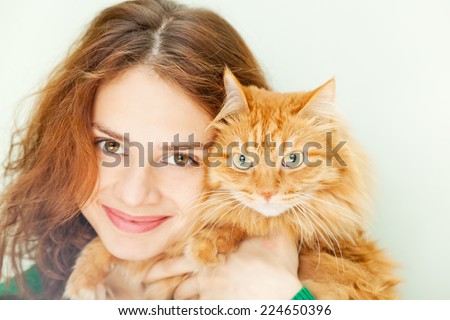 beautiful young woman with a red fluffy cat