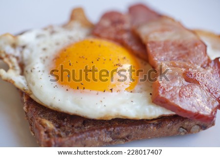 scrambled eggs on rye bread toast with bacon, close up