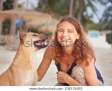 beautiful young woman with a dog, smiling and looking at the camera