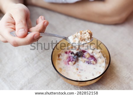 woman eating cereal with milk, close-up hands