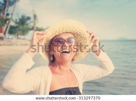 Happy mature woman of 50 years on the beach