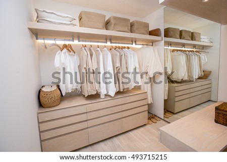 modern closet with row of white shirt hanging in wardrobe