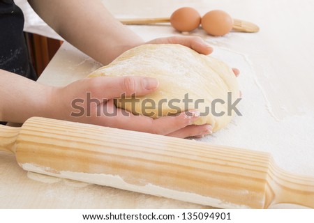 taking the dough with both hands together with a roller