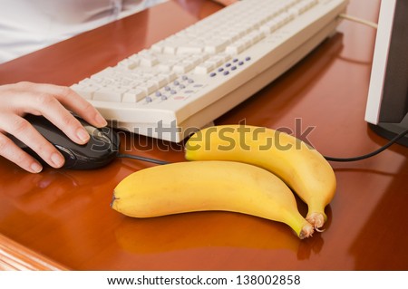 woman working on a computer with some banana to eat
