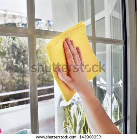 Woman Cleaning A Window With Yellow Cloth