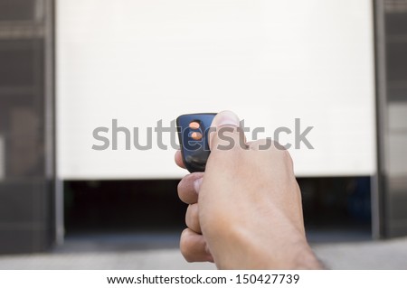 Hand Pressing A Remote Control With The Door Open