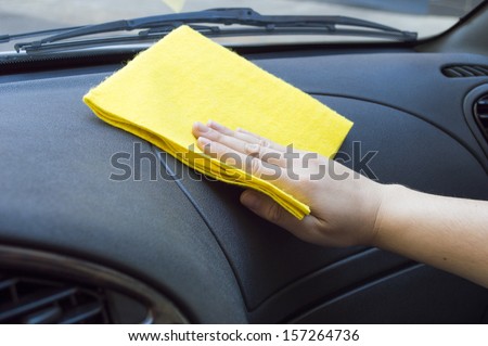 man cleaning the car interior with yellow cloth