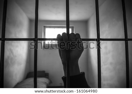 Hand Of A Prisoner Grabbed The Bars Of The Prison
