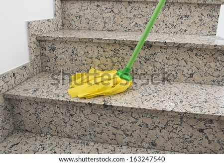 Close Up Of Stairs With Yellow Mop Cleaning