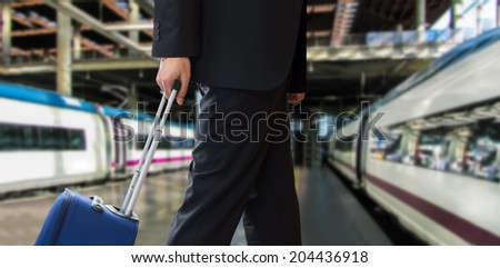 close up of businessman walking travel bag by train station
