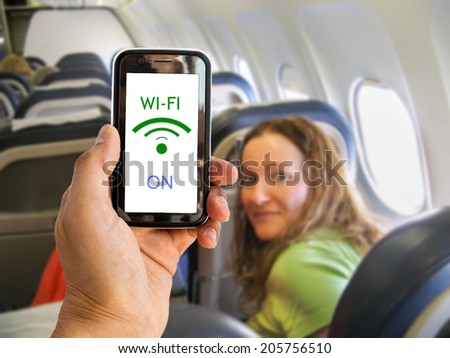 Hand holding mobile smart phone with connect wifi on the airplane