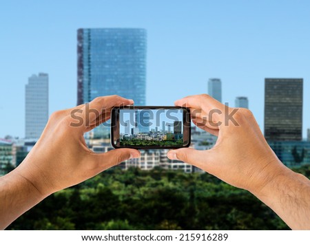 tourist holds up camera phone and shoot photography the city
