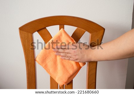 hand wiping with a cloth orange chair