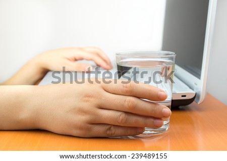 woman working at the laptop and drinking fresh mineral water