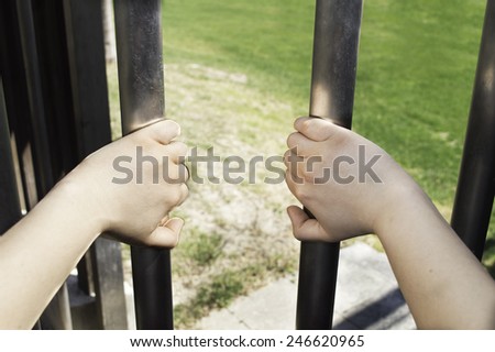man hands trying to open a prison bars