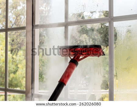 close up of cleaning window glass with steam