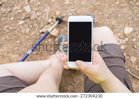 Hiker woman asking medical help with your phone after an accident