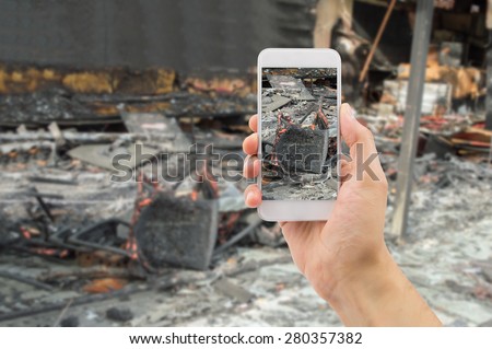 man photographing the damages of the home affected by the fire for home insurance