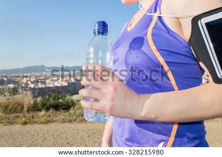 Thirsty sport runner resting taking a break with water bottle drink outside
