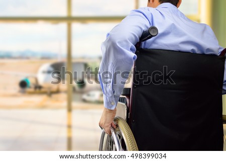 rear view of a business man in wheelchair at the airport with focus on hand