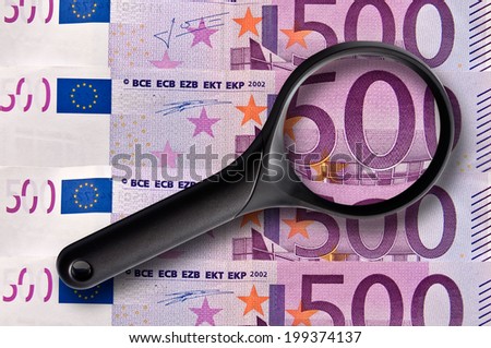 500 euros banknotes and magnifying glass close-up