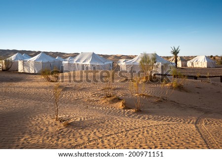 Camp of tents in a beautiful landscape of sand dunes in the desert of Sahara, South Tunisia