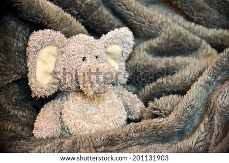 Stuffed fluffy animal in a soft blanket