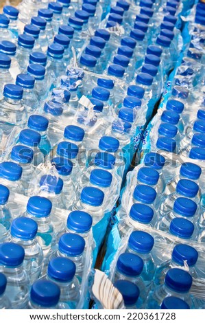 Many water plastic bottles with blue caps