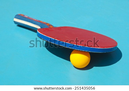 Close up of table tennis racket and ball on a blue table