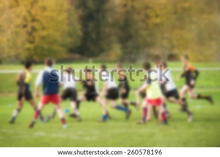 Blurred background of unidentified boys playing a team sport game, outdoor