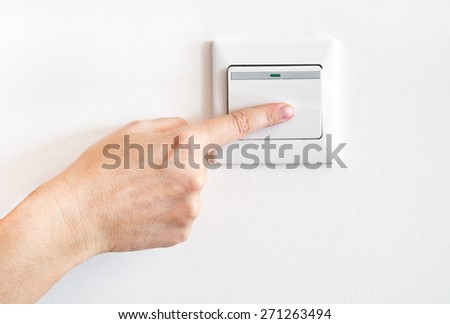 Hand with finger on light switch