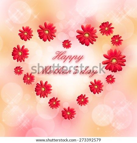 Happy mothers day written in a heart made of red daisy gerbera flowers, blurred pastel bokeh background