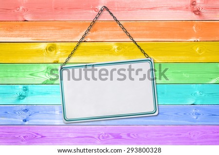 Metal plate sign hanging on a pastel colorful rainbow painted wood planks background