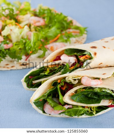 Close up of a wrap sandwich with lettuce and shrimps