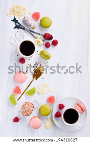 Two cups of coffee with macaroons and jellies shot from above
