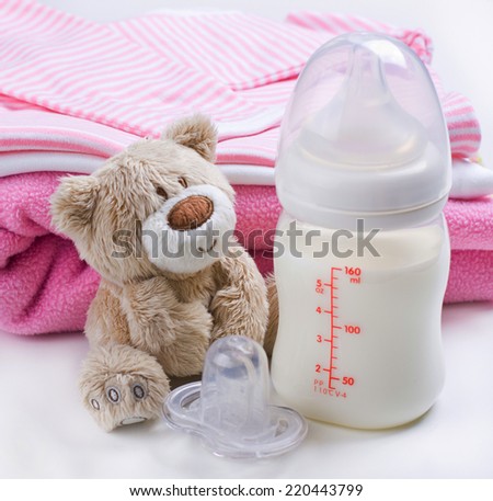 Baby girl\'s stuff, including bottle with milk and soft toy