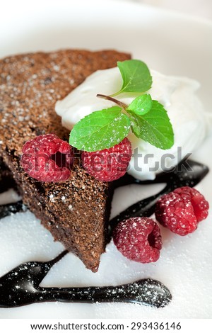 Chocolate brownie with raspberry , cream and mint