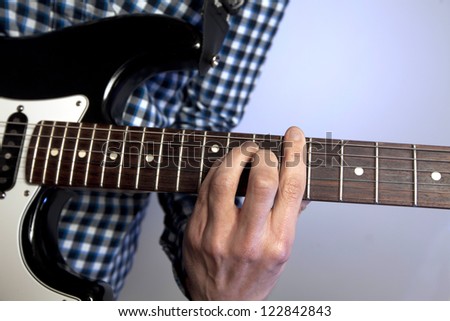 Closeup of man\'s hand on guitar frets