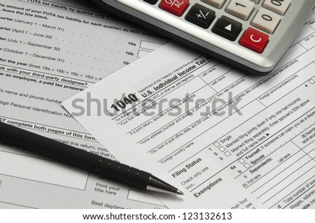 Desk with financial and tax papers, calculator  and pen
