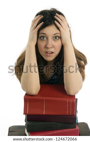 Female student resting arms on stack of books with overwhelmed expression