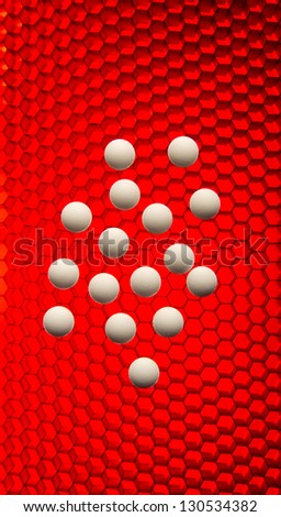 Grouping of white pills on a red high tech grid background