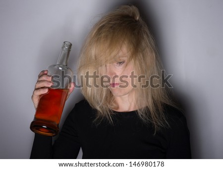 Alcoholic disease concept woman with whiskey bottle with shadows