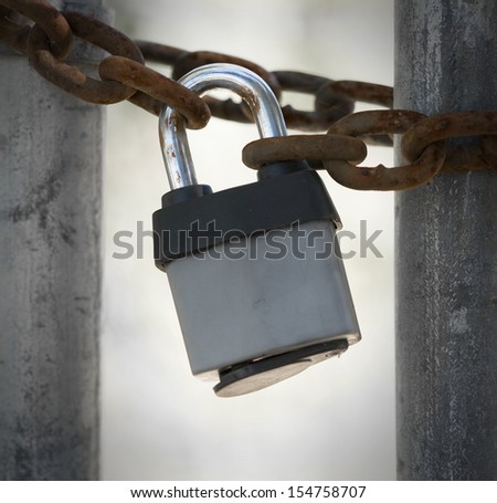 Closeup of gate locked with padlock at abandoned factory