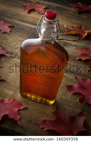 Organic Maple Syrup On Wooden Background With Maple Leaves