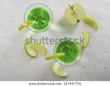 Closeup of green apple martinis in overhead view with apple slices